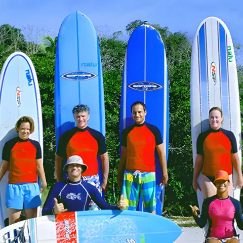 Groupe d'élèves avec leurs longboards sur la plage