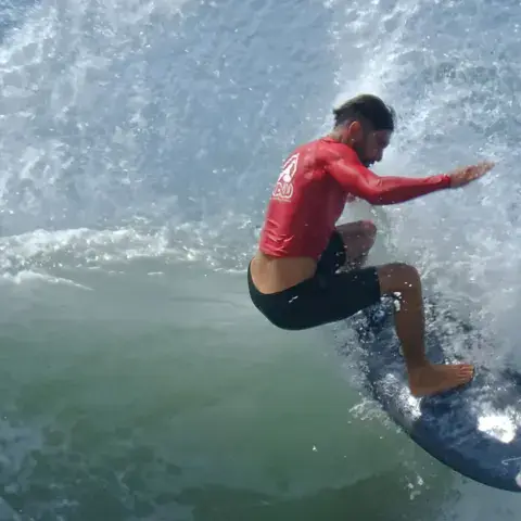 Surfeur en pleine manœuvre sur une vague