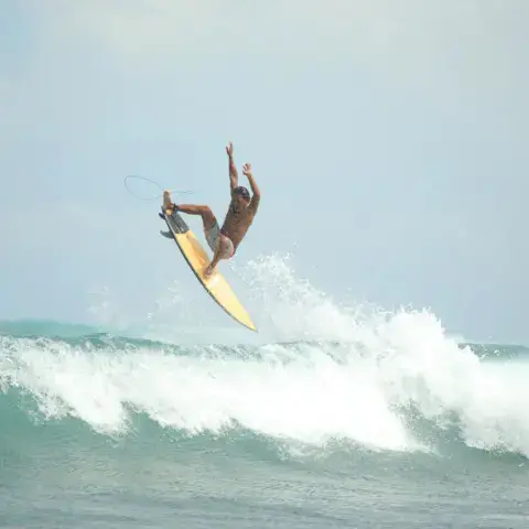 Un surfeur en l'air au-dessus d'une vague