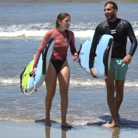 Deux surfeurs qui sortent de l'eau avec leurs planches