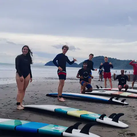Élèves avec leurs planches sur la plage avant le cours