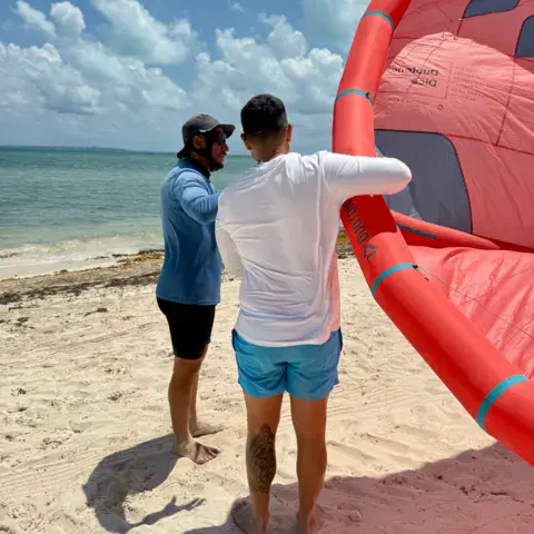 Briefing sur la plage avant la session, avec un kite rouge