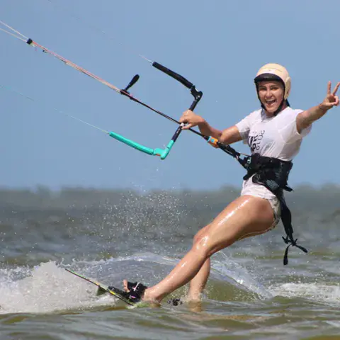 Kitesurfeuse en navigation dans l'eau peu profonde