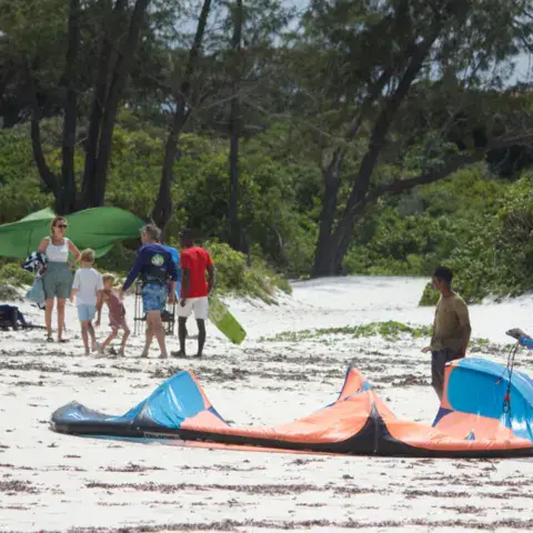 Kites étalés sur la plage, au point de départ des cours
