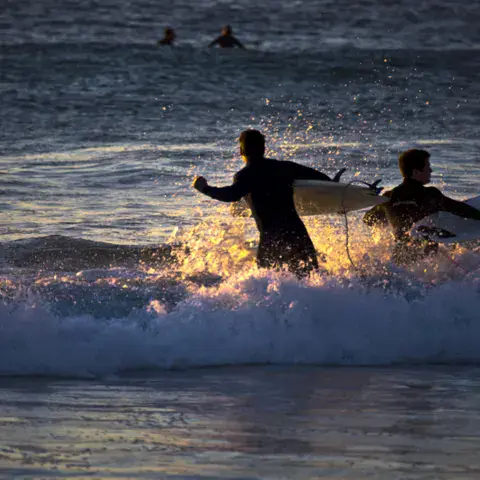 Surfeurs dans les vagues en fin de journée