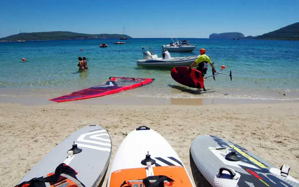 Planches de windsurf sur la plage et bateau de sécurité dans l'eau