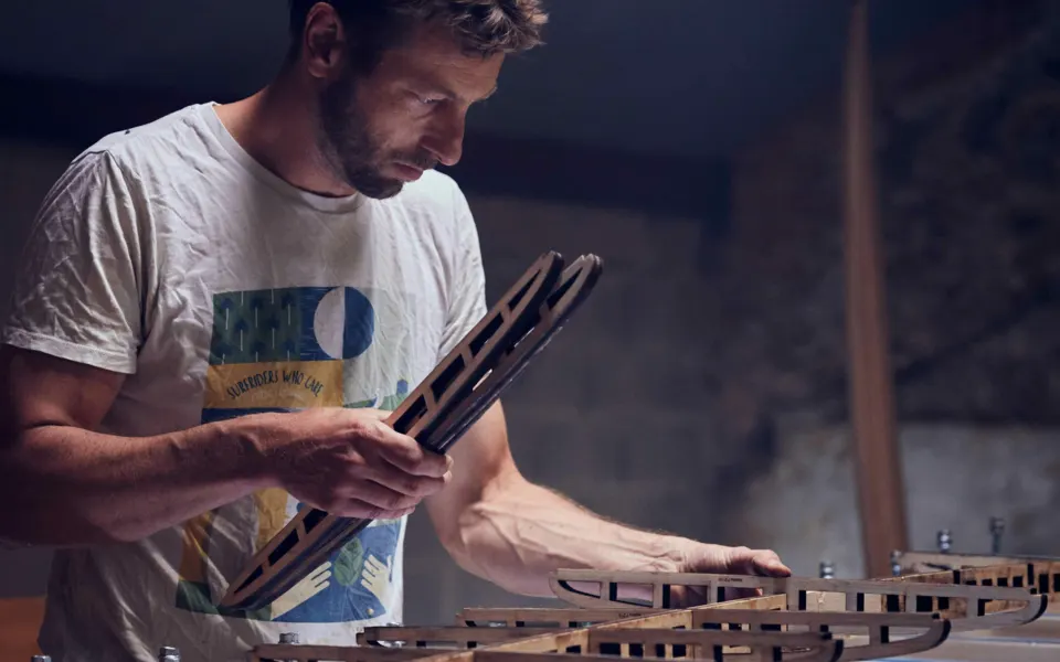 Un artisan assemble une structure en bois dans l'atelier