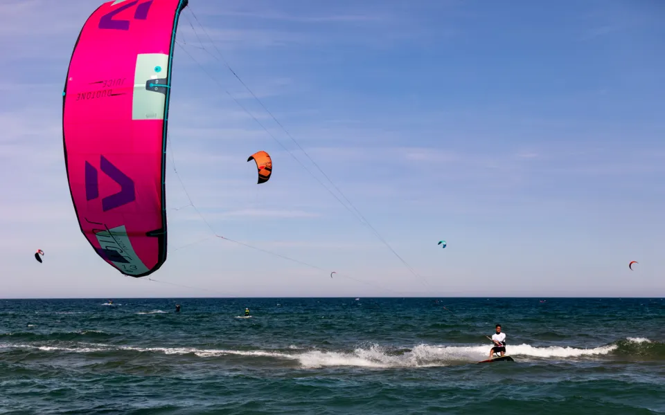 Kitesurfeur en navigation sous une aile rose