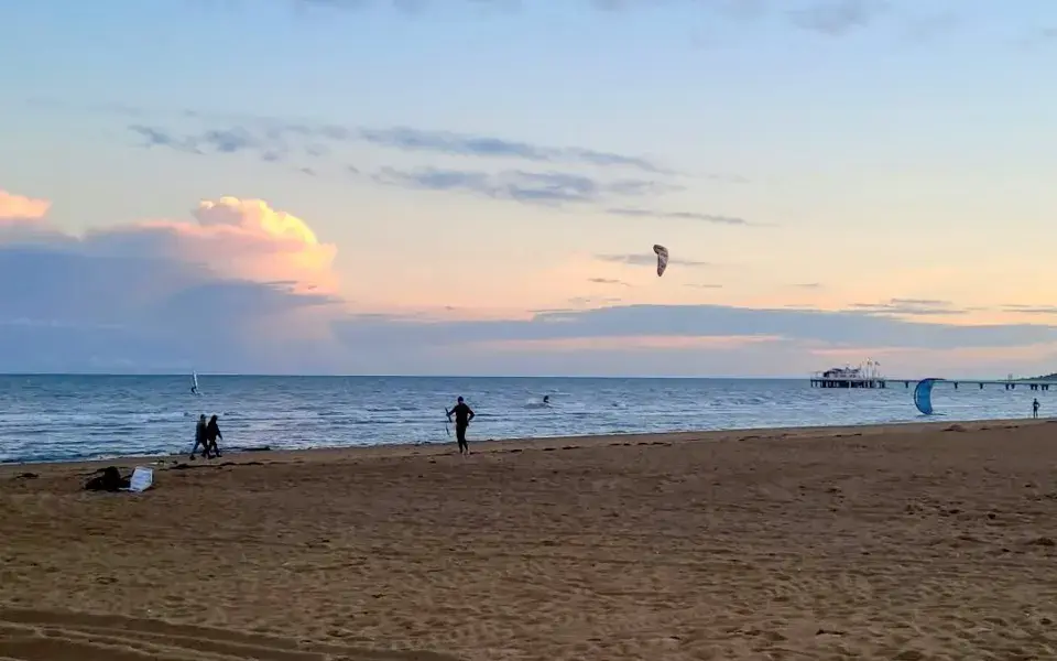 Kitesurfers au large de la plage de Lignano Sabbiadoro au coucher du soleil