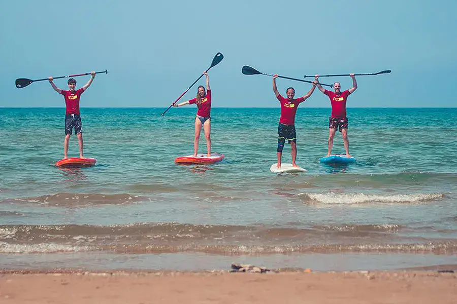 Cours collectif de stand up paddle en bord de plage