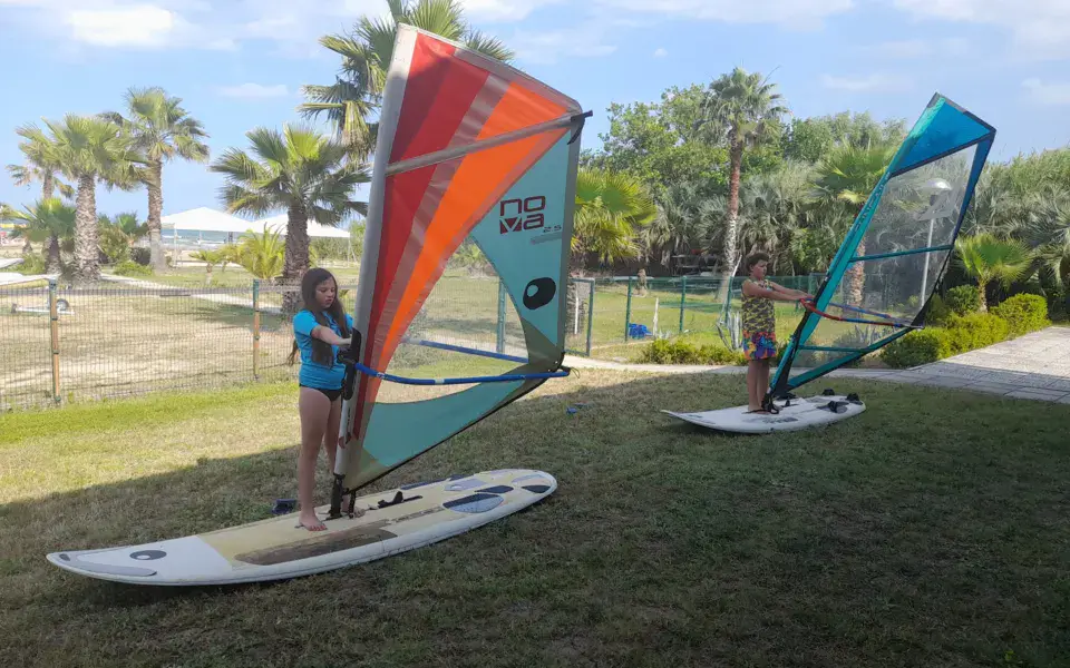 Gréements de windsurf alignés sur la pelouse du club