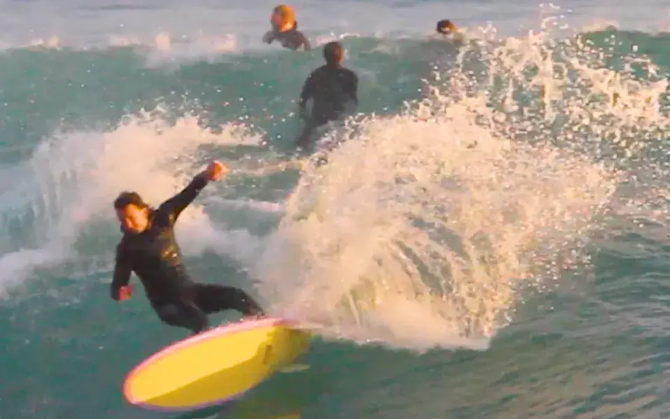 Surfeur sur une planche jaune dans les vagues