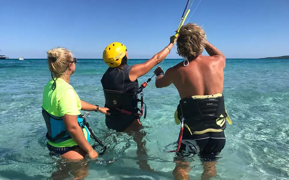 Cours de kitesurf dans l'eau peu profonde, avec casque et radio