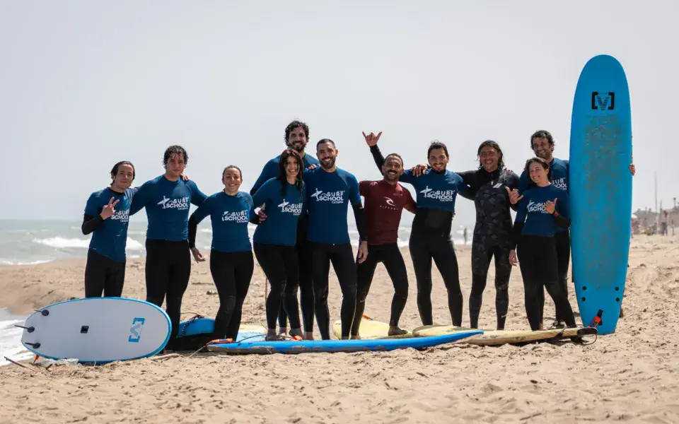 Groupe d'élèves avec leurs planches sur la plage