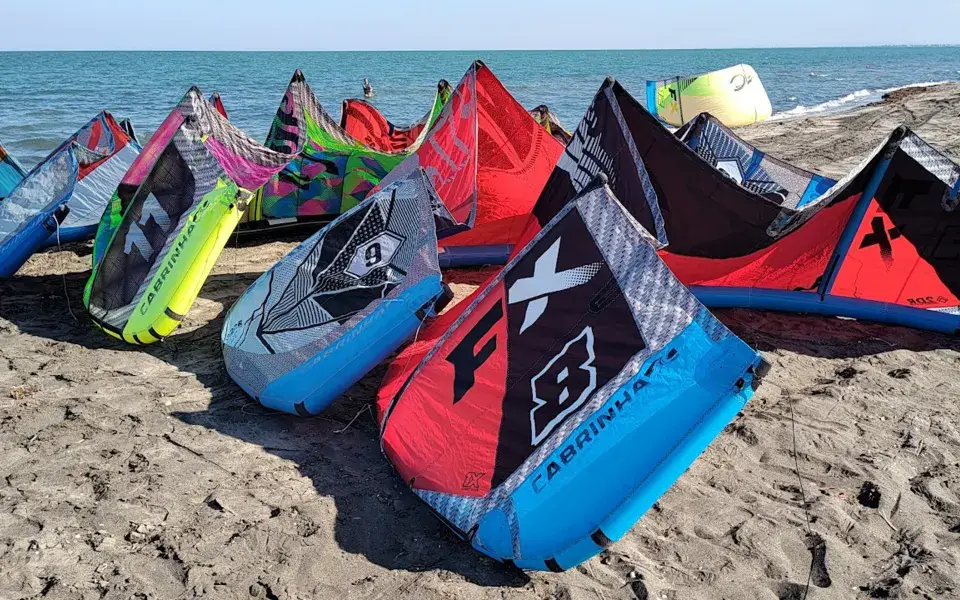 Kites de kitesurf alignés sur la plage