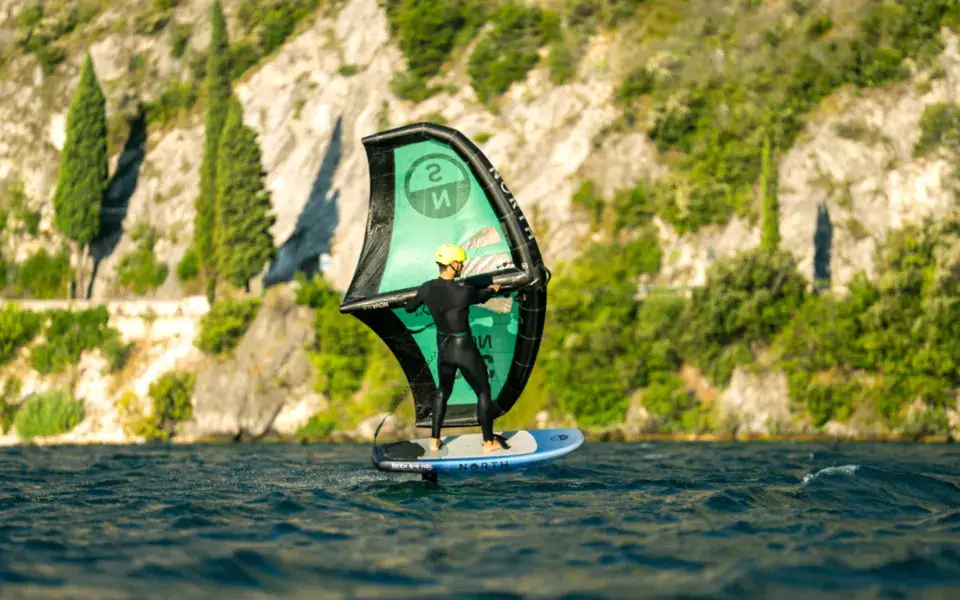 Wingfoiler sur le lac devant la falaise