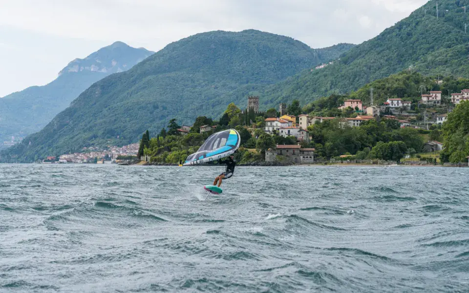Wingfoiler sur le lac de Côme devant la rive de Cremia