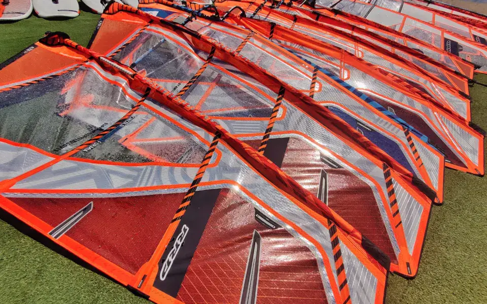 Voiles de windsurf alignées sur la plage