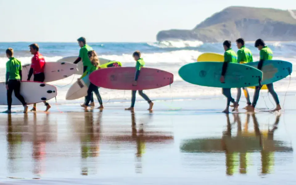 Groupe d'élèves avec leurs planches au bord de l'eau