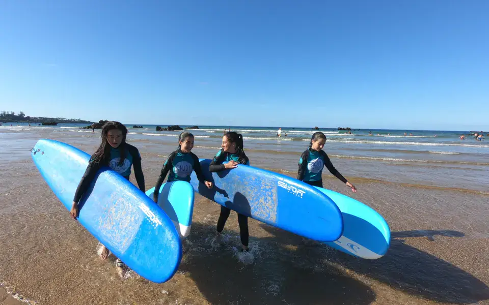 Élèves avec leurs planches de surf sur la plage
