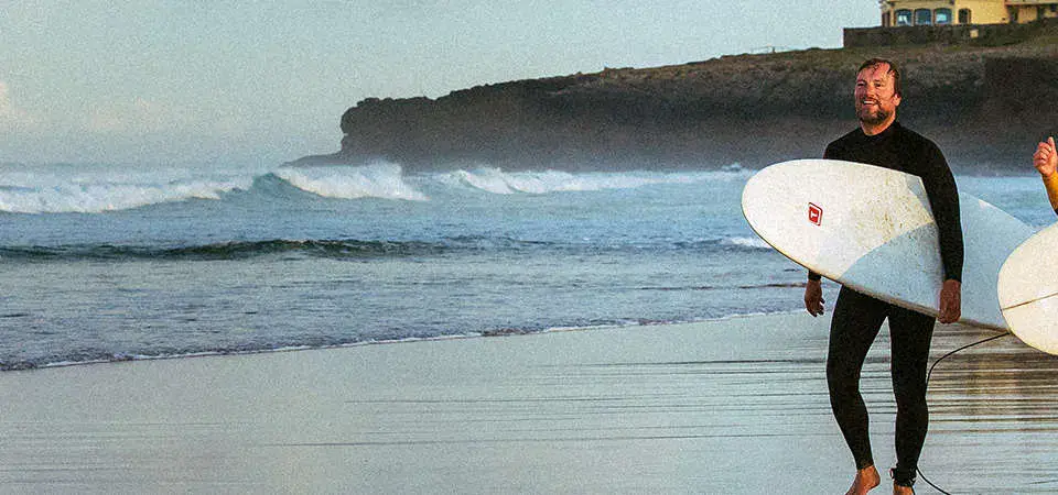 Deux surfeurs avec leurs planches sur la plage