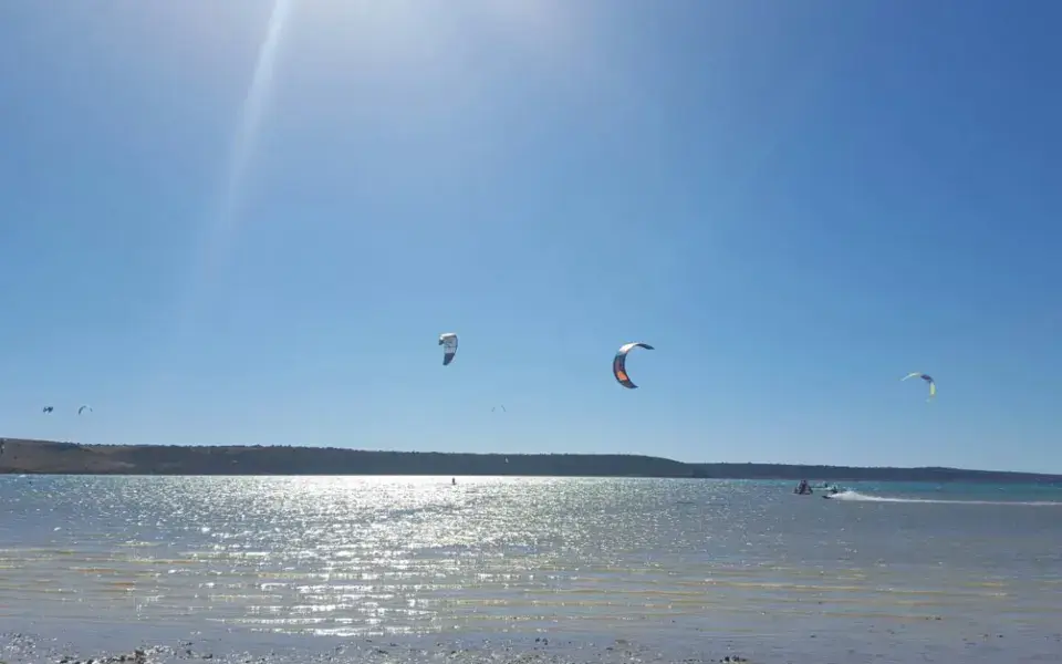Kites de kitesurf dans le ciel au-dessus d'une baie calme