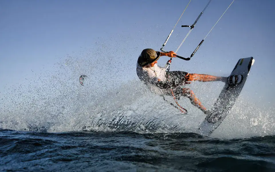 Kitesurfeur en action avec gerbe d'eau