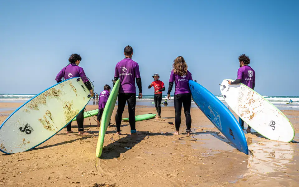 Groupe se rendant à l'eau avec des planches en mousse
