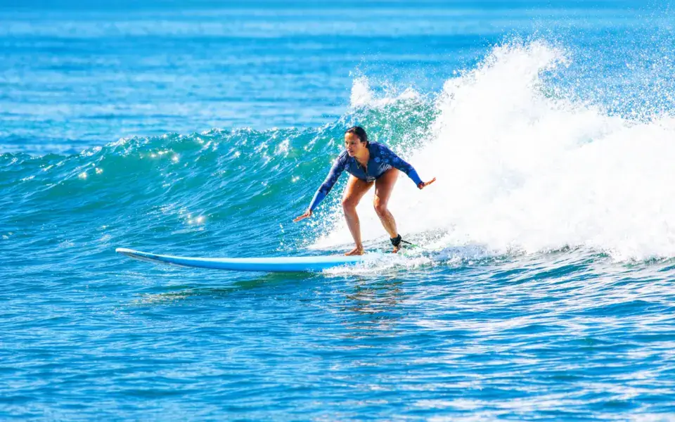 Surfeuse sur une vague pendant un cours à Haleiwa