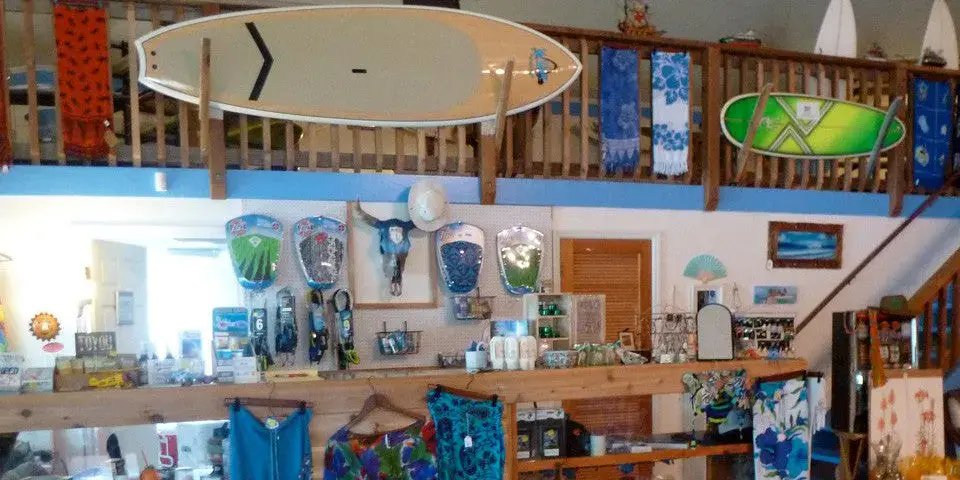 Intérieur du magasin : planches de paddle et vêtements