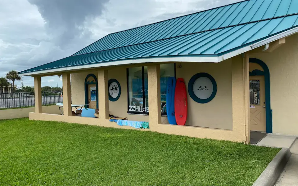Intérieur du magasin Mad Dog Surf Shop, avec les rayons de vêtements et de planches