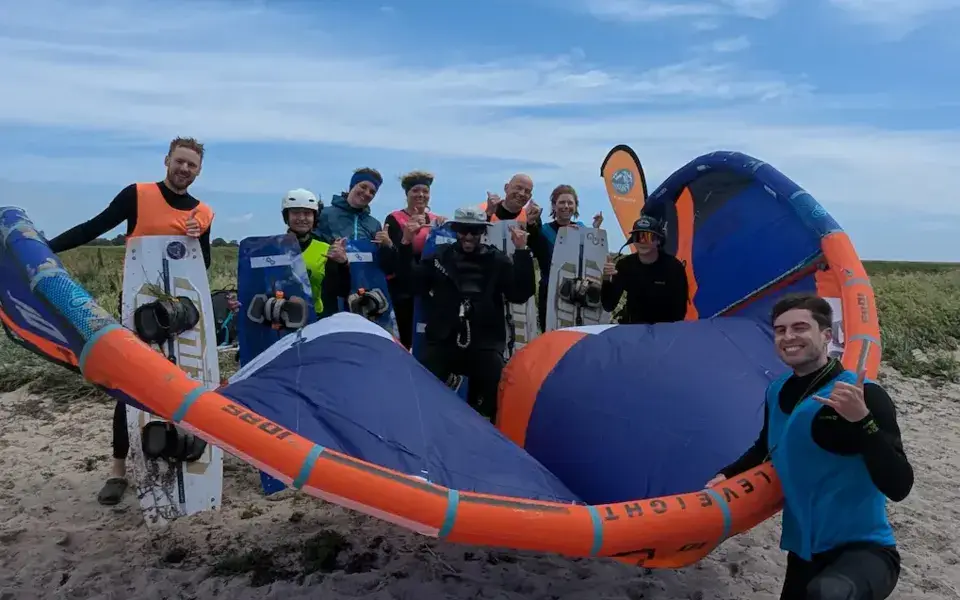 Groupe d'élèves et de moniteurs avec un kite sur la plage