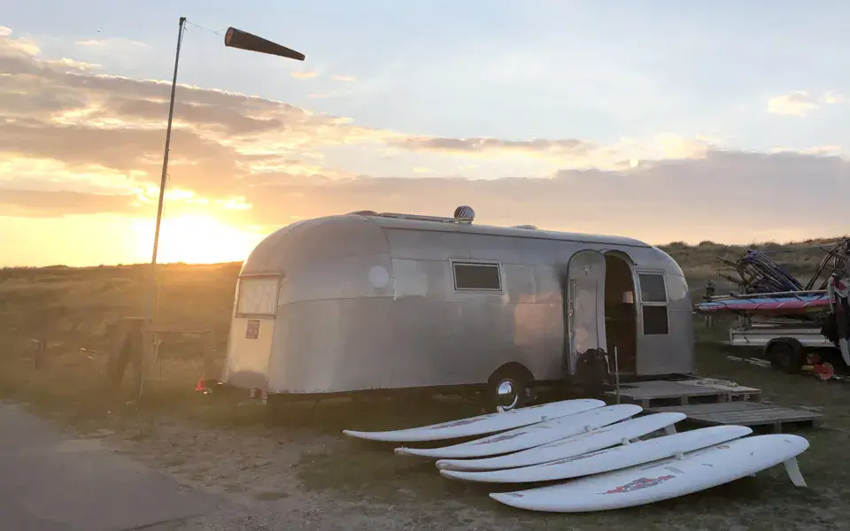 Caravane et planches de paddle au coucher du soleil