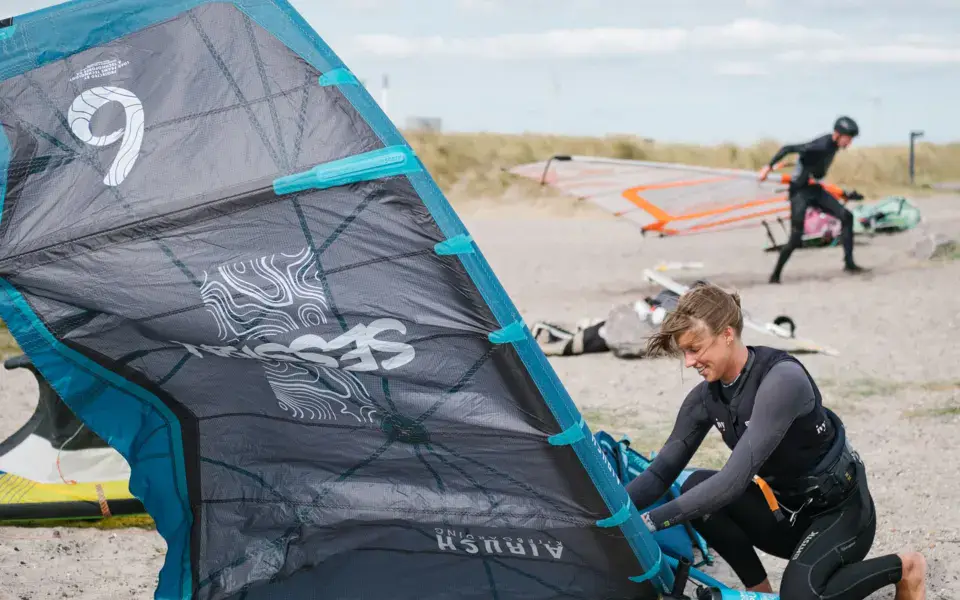 Préparation d'une aile de kite sur la plage