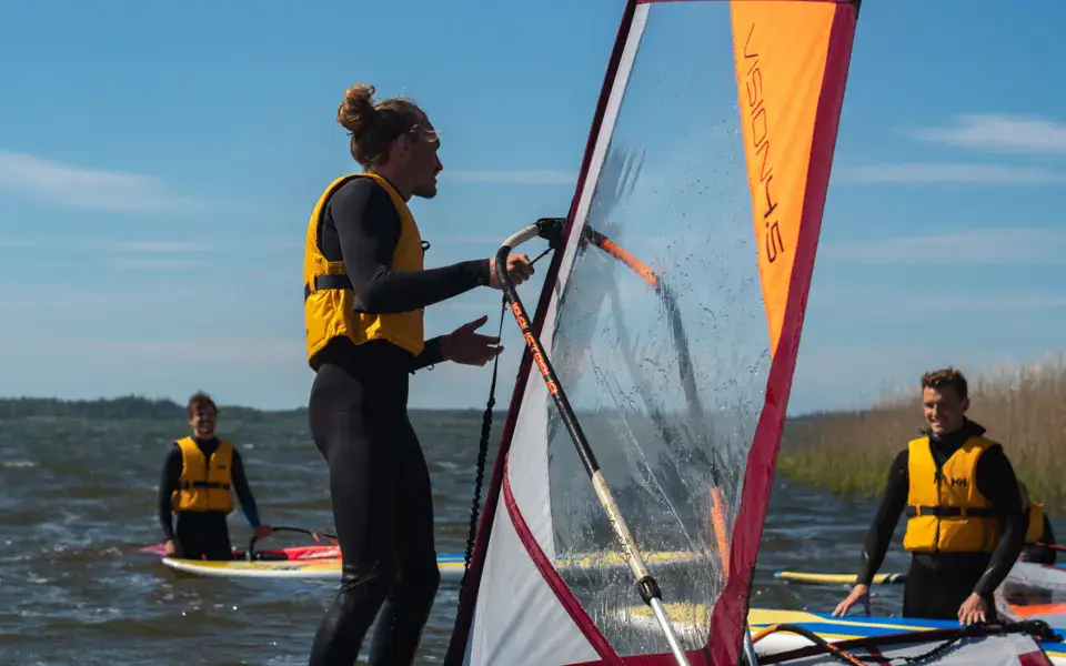 Cours de windsurf sur plan d'eau abrité, élèves en gilets jaunes