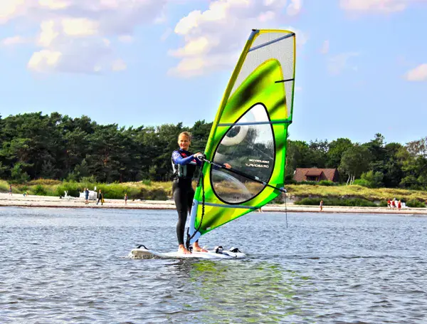 Élève de windsurf sur sa planche près de la plage