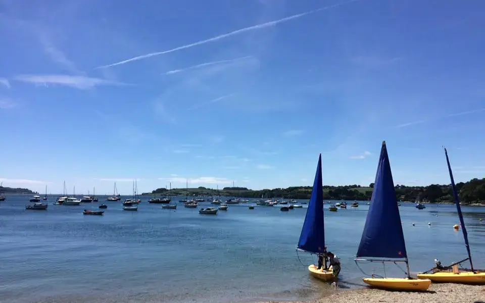 Plage de galets avec dériveurs et kayaks