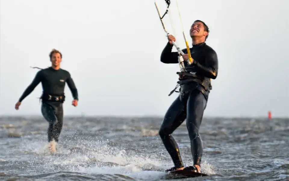 Kitesurfeur en action, un moniteur derrière lui