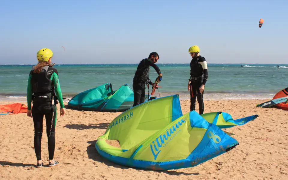 Préparation des kites sur la plage avant un cours