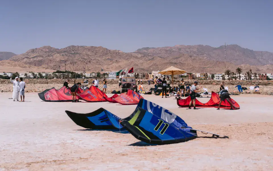 Des kites étalés sur la plage, face aux montagnes du Sinaï