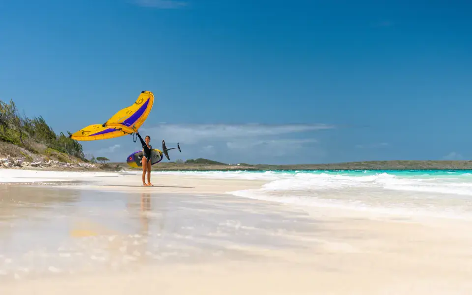 Pratiquant de wing foil sur la plage du lagon