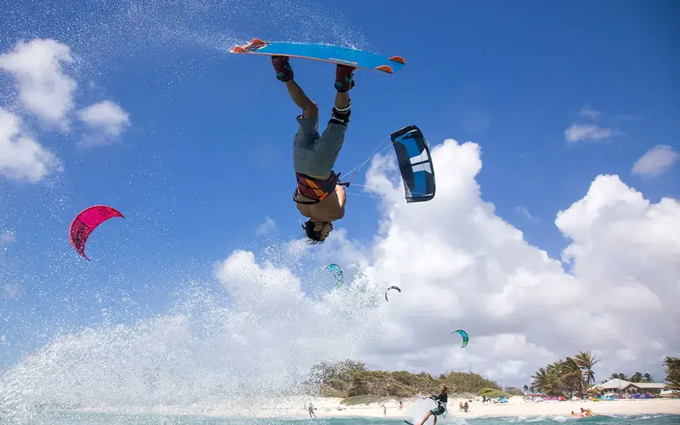 Kitesurfeur en plein saut au-dessus d'une plage