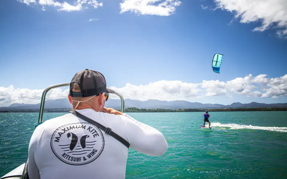 Rider en kitesurf suivi depuis le bateau de l'école