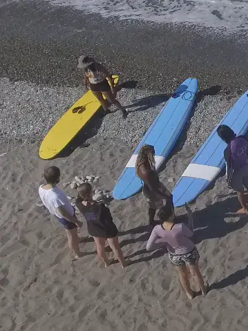 Un groupe d'élèves avec des planches sur la plage