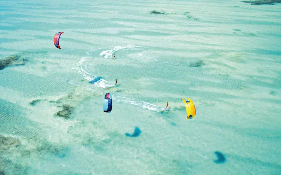 Vue aérienne de kitesurfeurs sur un lagon peu profond