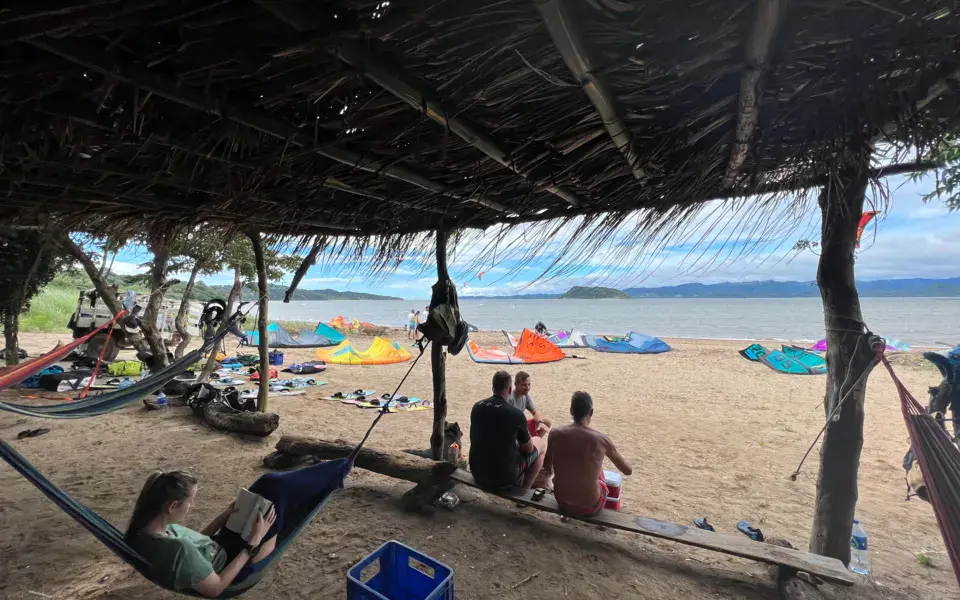 Abri en palmes sur la plage, au milieu des kites