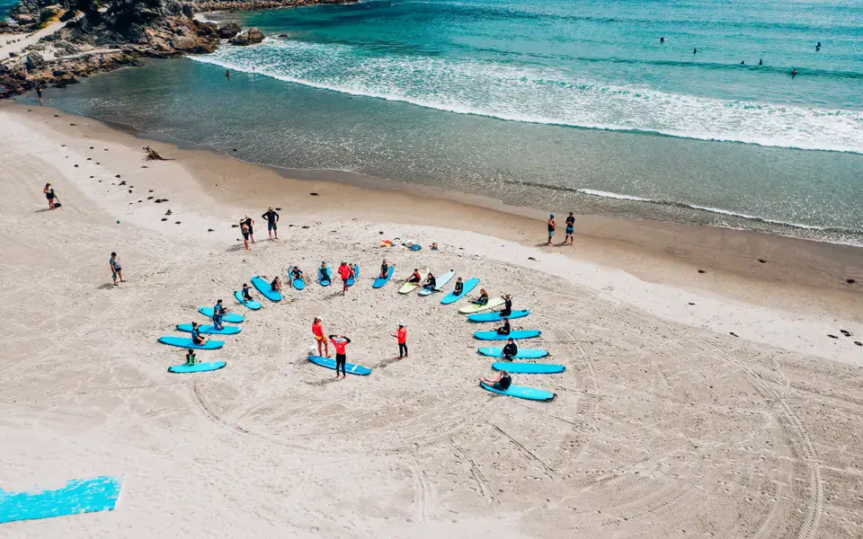 Vue aérienne d'un cours collectif sur la plage, planches disposées en cercle