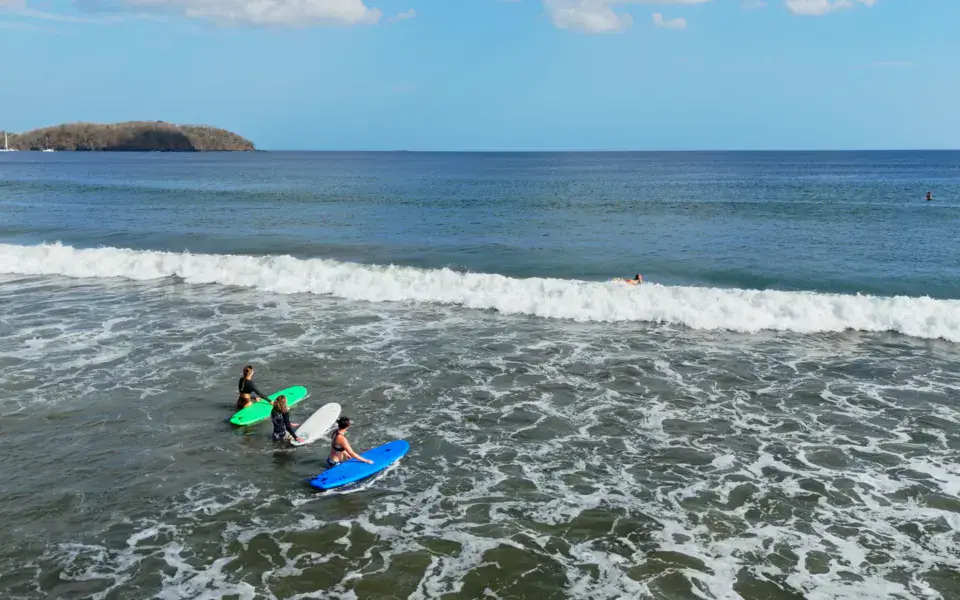 Élèves sur leurs planches dans les vagues de Playa Venao, vus du ciel