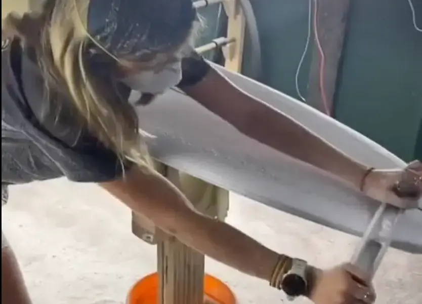 Ponçage d'une planche de surf à l'atelier
