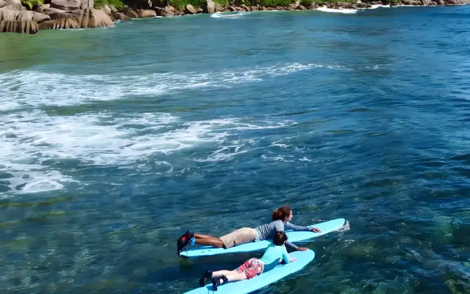 Deux élèves allongés sur des planches de surf en mousse